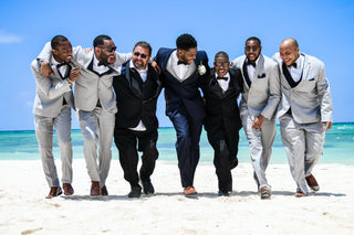 A group of wedding guests smiling on the beach