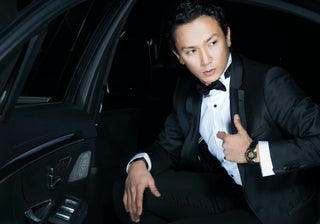 A man wearing a tuxedo getting out of a car